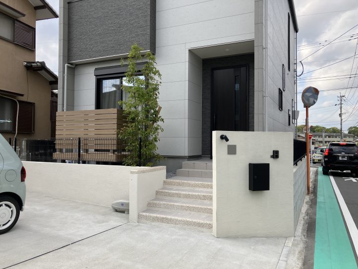 モザイクタイルの階段と目隠しフェンスがついているウッドデッキ