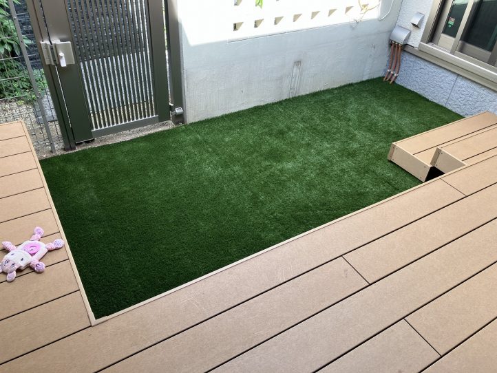 コの字型デッキと人工芝が広がる、明るく開放的な仕上がりのお庭です。