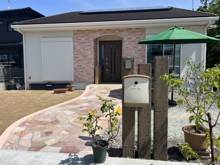 コンクリート枕木の門柱に乱形石貼りのアプローチ　ナチュラルな外構