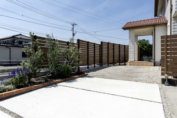 花壇や目隠しフェンスに囲われたインターロッキングのアプローチ