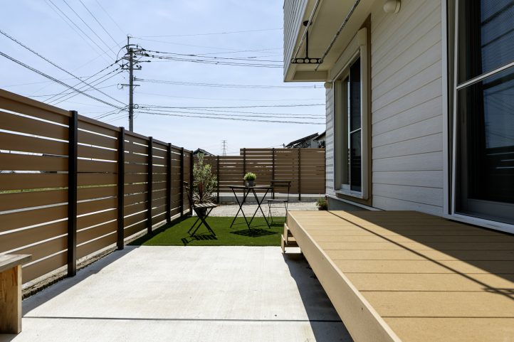 目隠しフェンスで囲われたデッキと人工芝のお庭